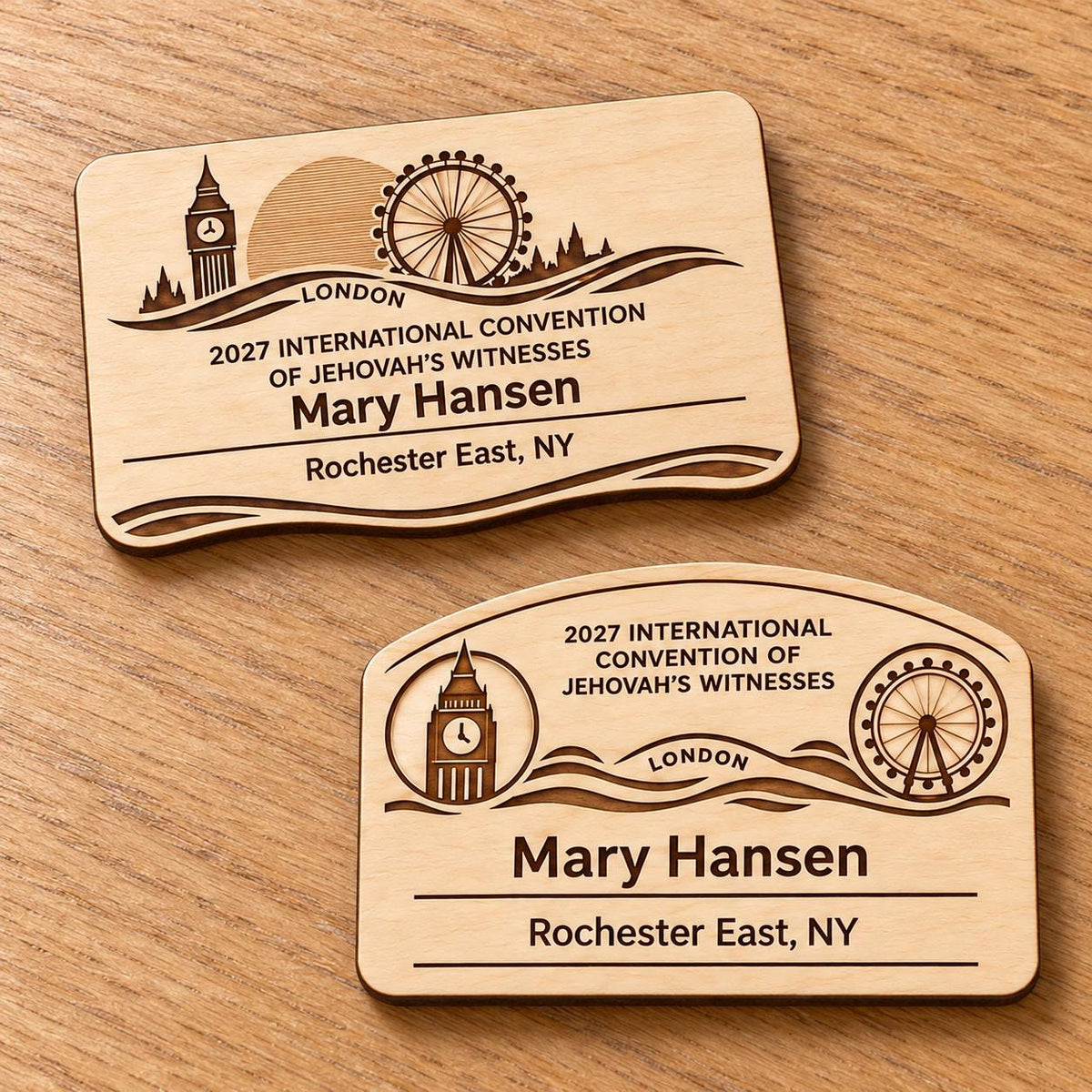 Two London mini natural-birch engraved badge designs, slot-free and laid separately on a light oak tabletop; each shows sample personalization.