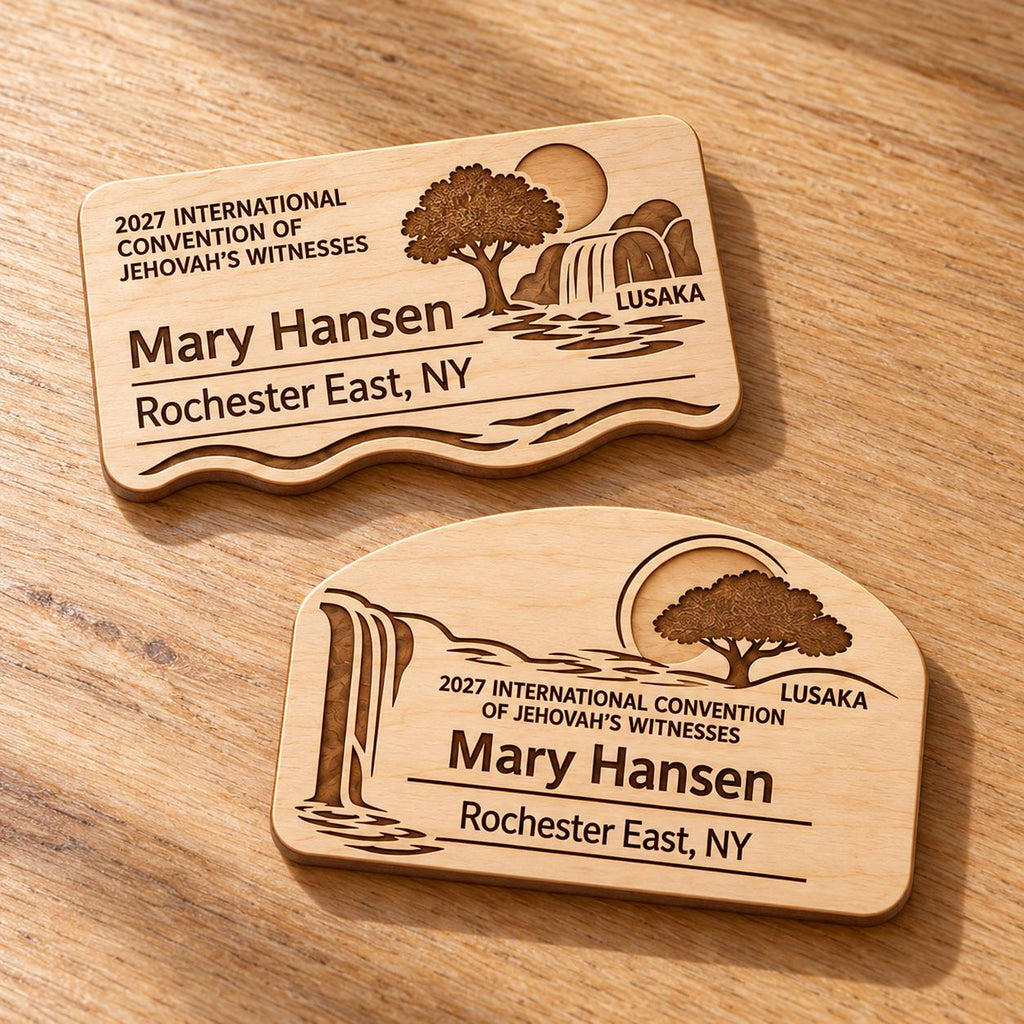 Two Lusaka mini natural-birch engraved badge designs, slot-free and laid separately on a light oak tabletop; each shows sample personalization.