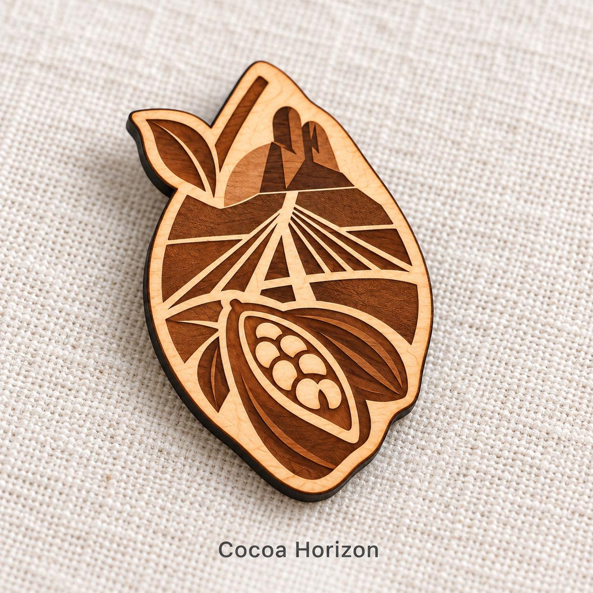 Close-up of Abidjan Cocoa Horizon engraved birch pin on linen, with design name caption.