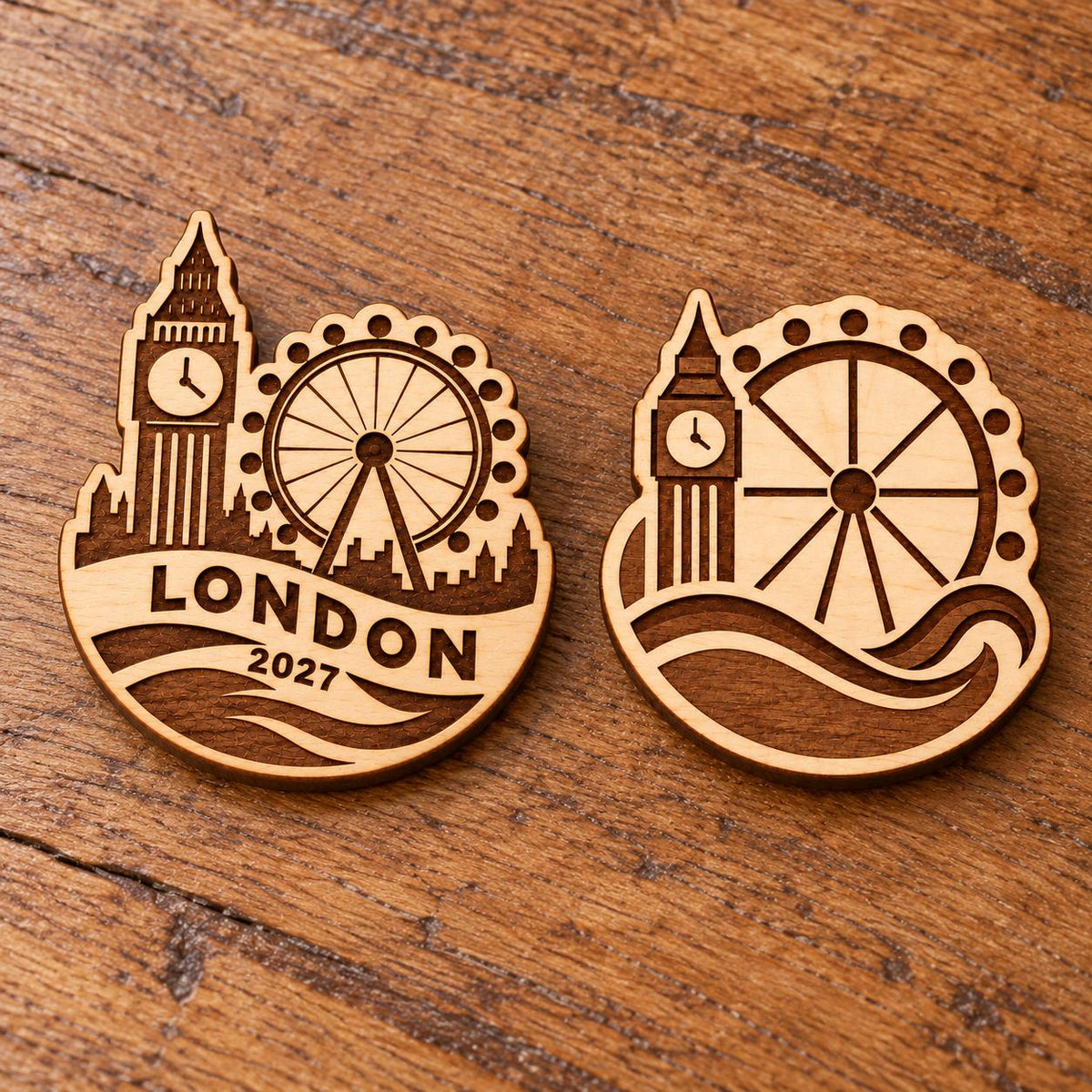 Two London engraved birch convention pin designs lying face-up on a wooden table in natural light.