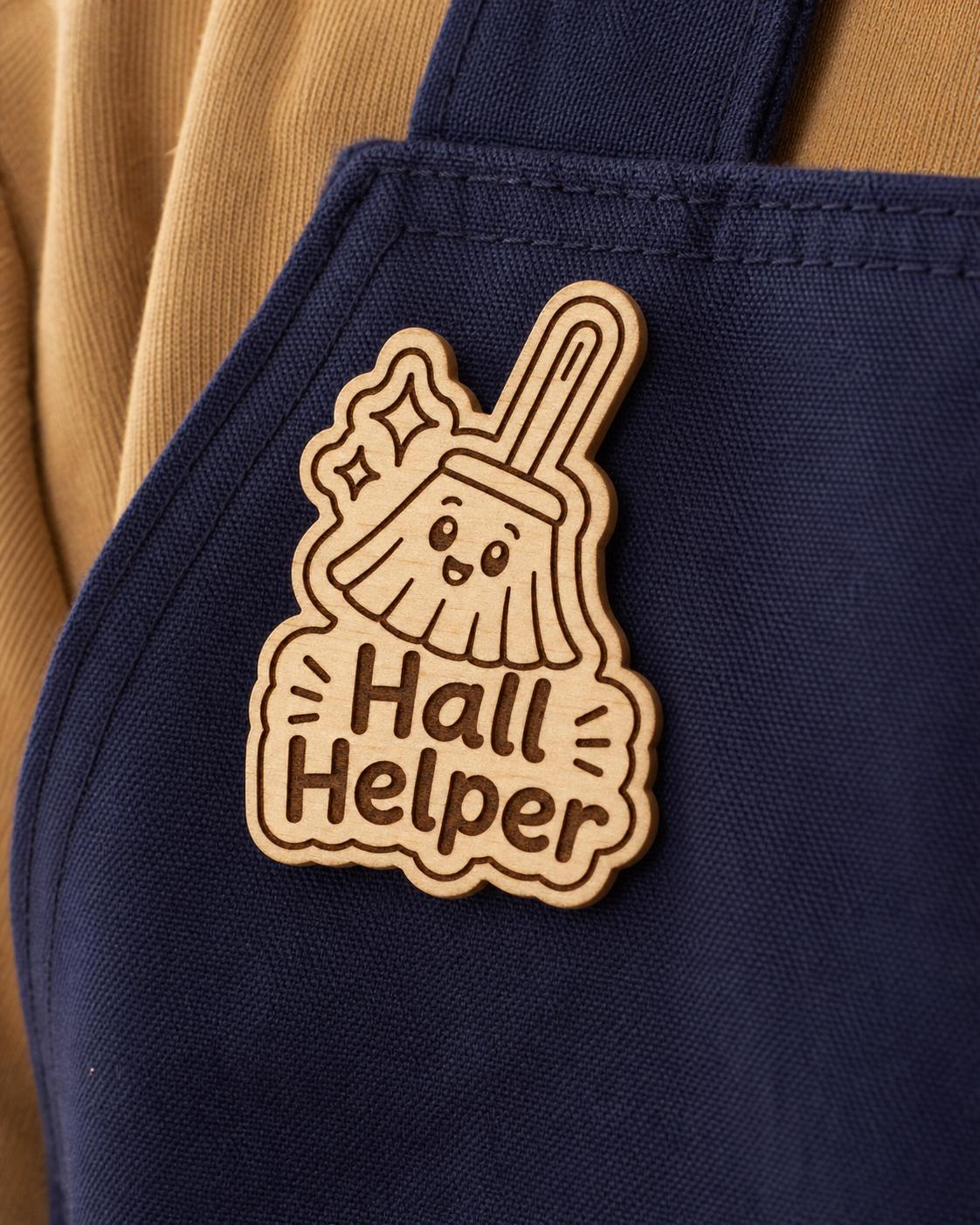 Close-up of the Hall Helper natural birch engraved accessory attached to fabric, showing its dark artwork and shaped edge.