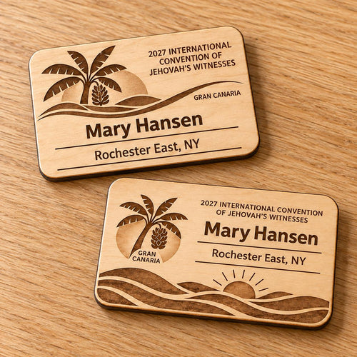 Two Gran Canaria mini natural-birch engraved badge designs, slot-free and laid separately on a light oak tabletop; each shows sample personalization.