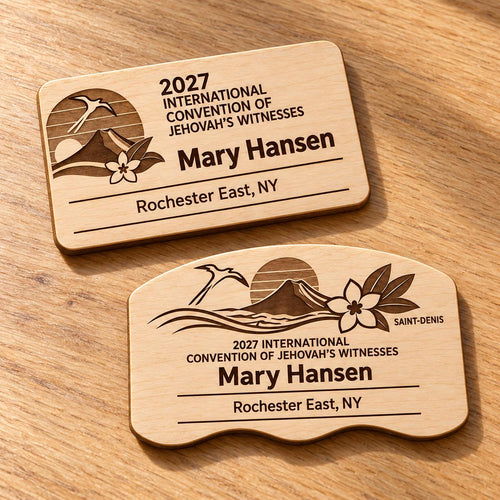 Two Saint-Denis mini natural-birch engraved badge designs, slot-free and laid separately on a light oak tabletop; each shows sample personalization.