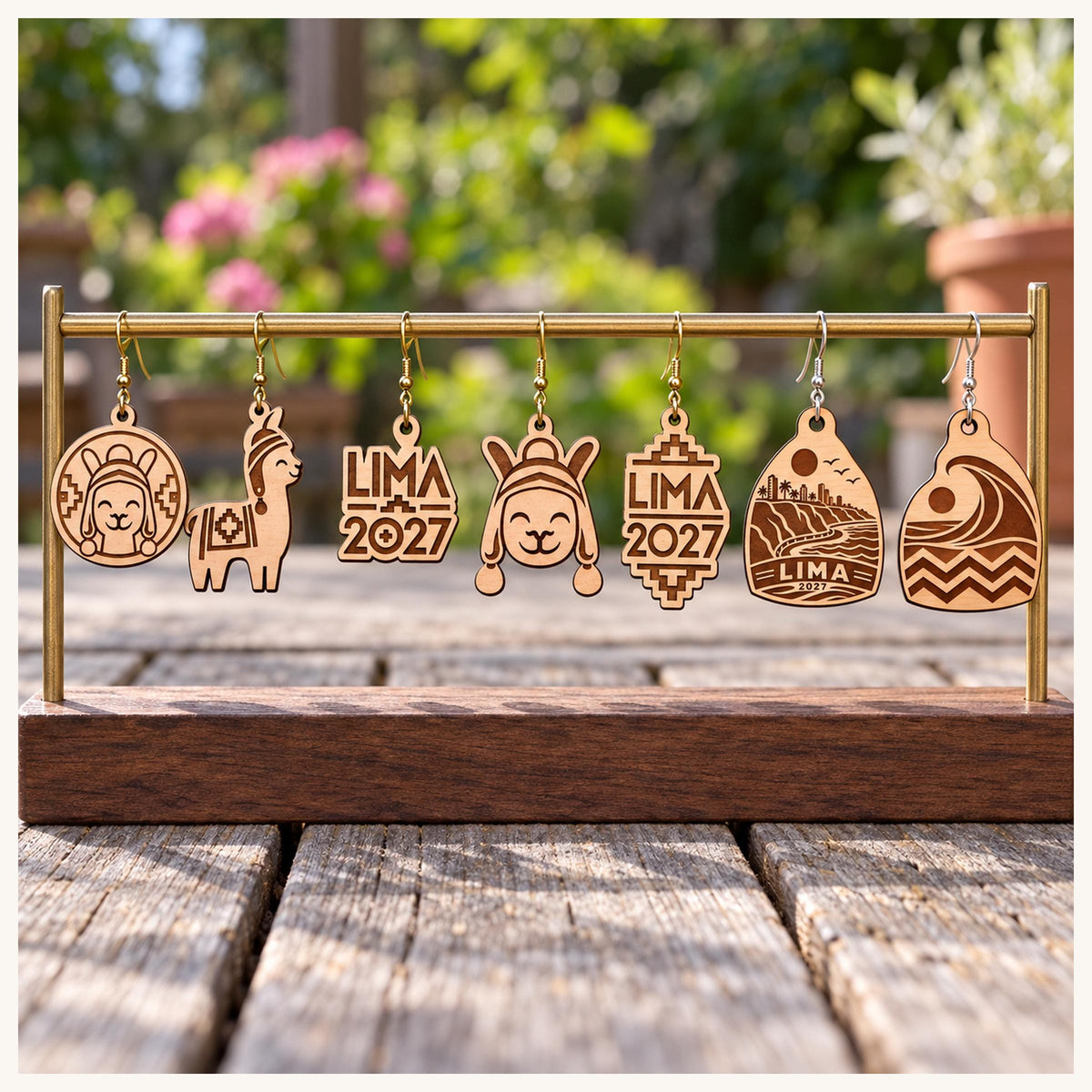One earring from each selected Lima 2027 birch design on a wooden display stand outdoors.