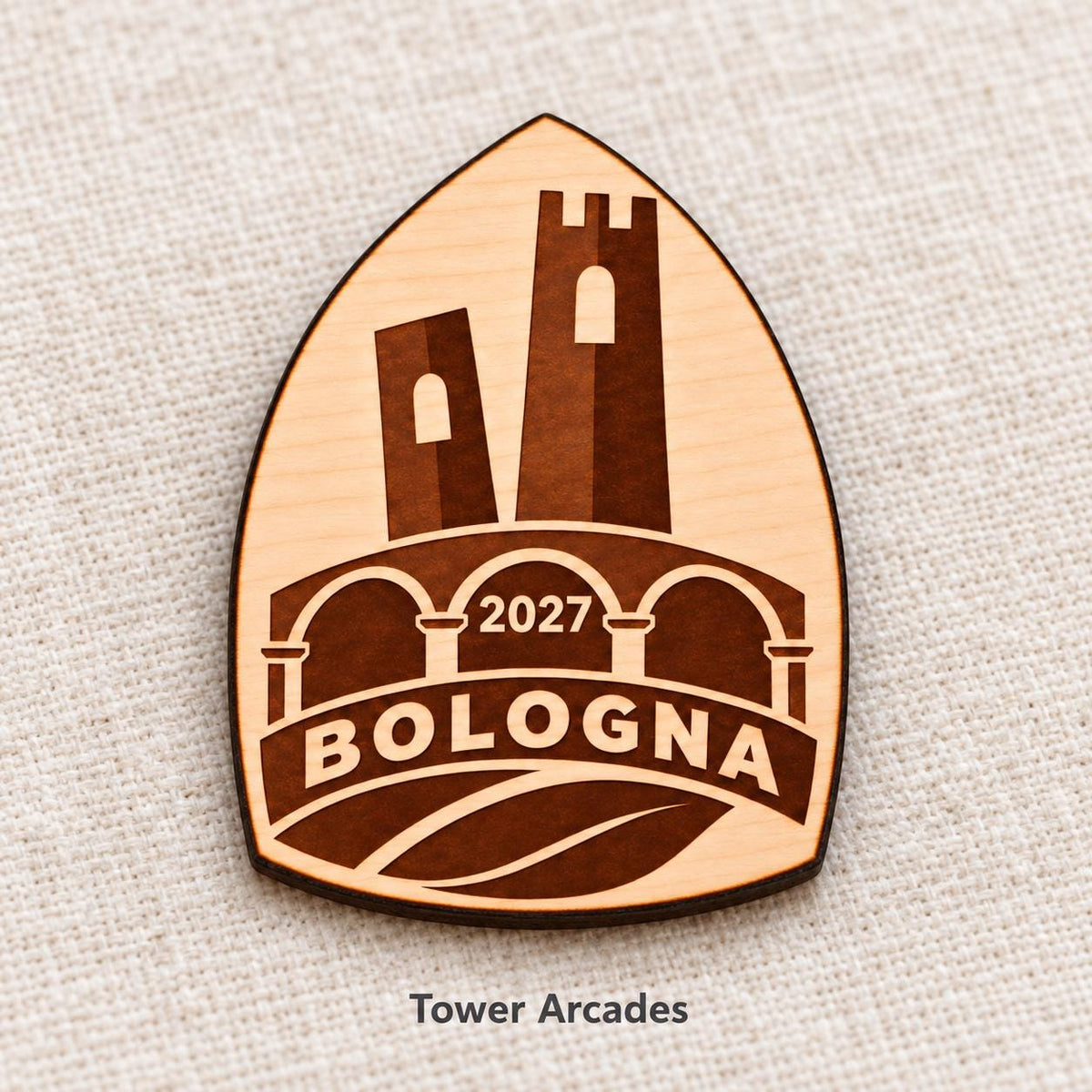 Close-up of Bologna Tower Arcades engraved birch pin on linen, with design name caption.