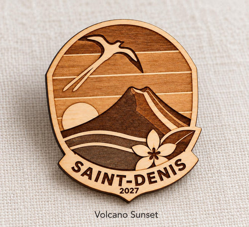 Close-up of Saint-Denis Volcano Sunset engraved birch pin on linen, with design name caption.