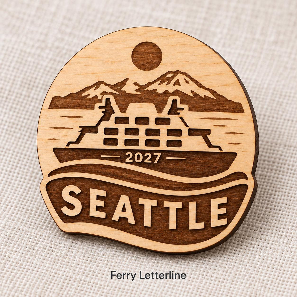 Close-up of Seattle Ferry Letterline engraved birch pin on linen, with design name caption.