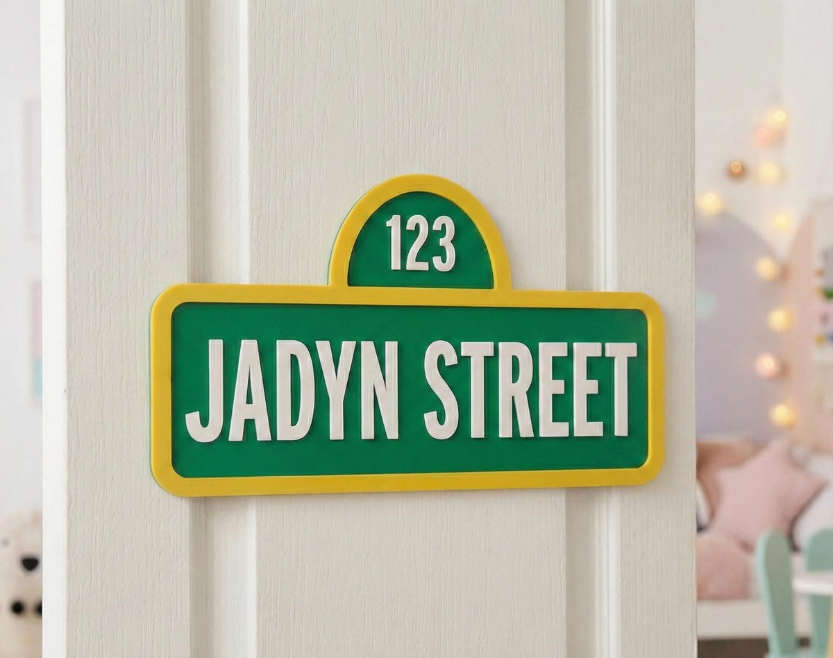 Green and yellow personalized street-style sign reading Jadyn Street and 123 on a white bedroom door.